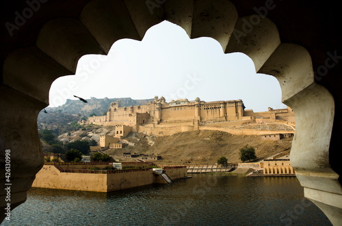 fortress seen through an arch in Hindu style. Amber fort, Jaipur, Rajasthan, India and Maota lake photo