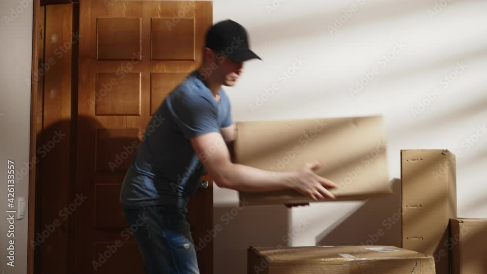 Handsome man in cap delivers cardboard boxes. Handsome man in cap delivers cardboard boxes.