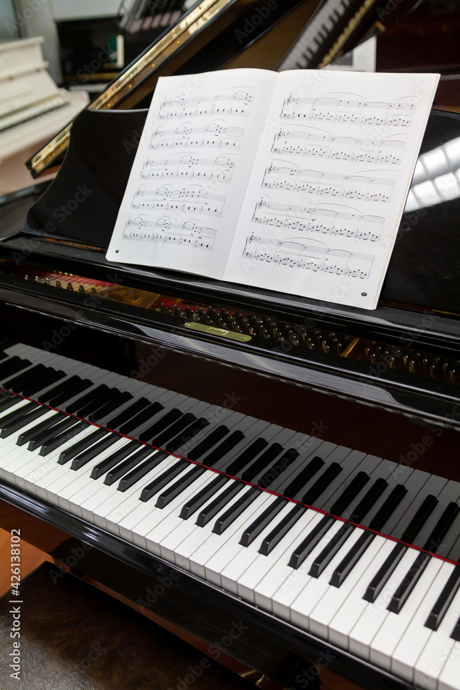 Clavier d'un piano noir et partition de musique sur le pupitre Stock Photo