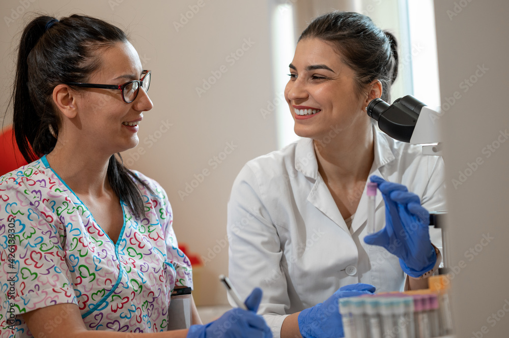 Fototapeta premium Two lab women technicians working together in the laboratory. 