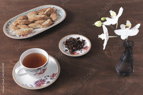 Cup with cascara coffee cherry tea and cantuccini cookie biscuits on a plate. photo