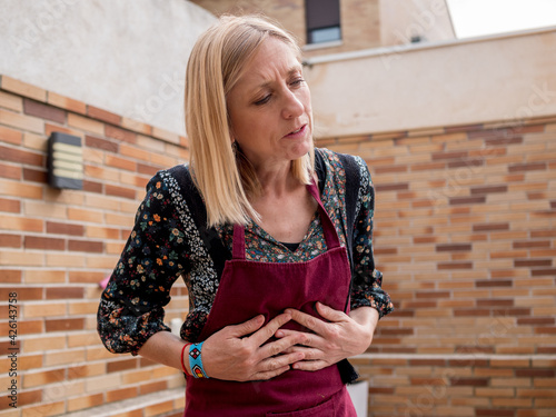 Woman in red apron with stomach ache