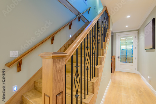 Beautiful living room interior with hardwood floors and vaulted ceiling in new luxury home. View of stairs, and second story.