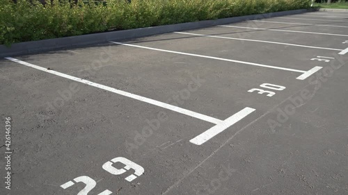 Close-up of a white paint number marking in a parking lot. Empty parking lot, Parking lot with white mark, Open parking in public park. Number 30. Video 4K.