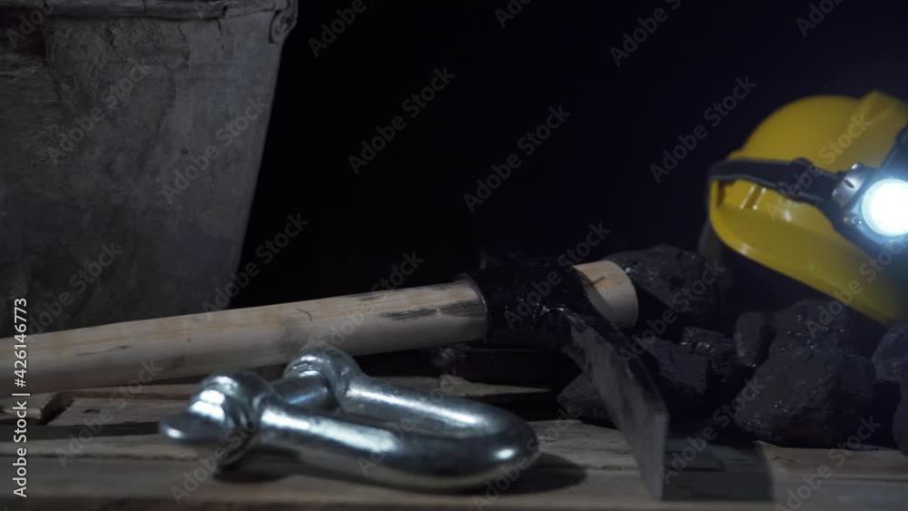 On the wooden platform you can see a bucket with charcoal, a protective mask with a filter and a helmet with a glowing flashlight On the wooden platform you can see a bucket with charcoal, a protective mask with a filter and a helmet with a glowing flashlight