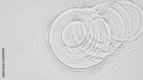 Up close, top view, Slow motion various waves of the water surface hitting the sun's rays, making them sparkle according to different patterns on a gray background video 4K.