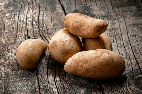 raw potatoes on wooden desktop