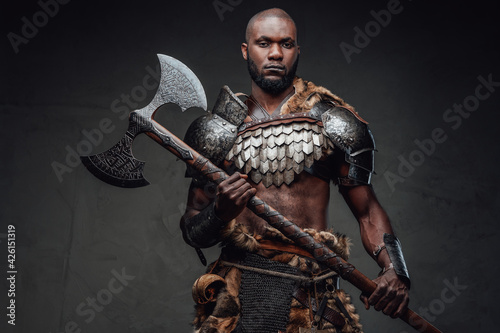 African furious viking in antique armour holding a huge steel axe