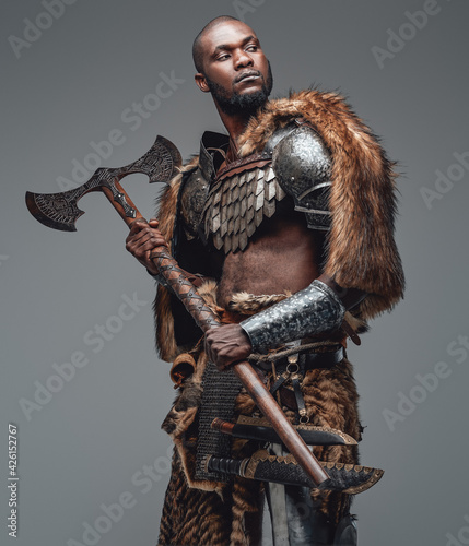 Proud warrior from the past in fur and armour holding a combat axe