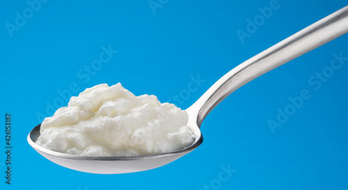 Fresh curdled milk, homemade sour yogurt in spoon