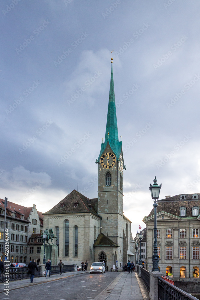 Obraz premium Vertical evening view of famous Fraumunster and bridge in historic Zurich city center on a cloudy afternoon in winter, Zurich, Switzerland.