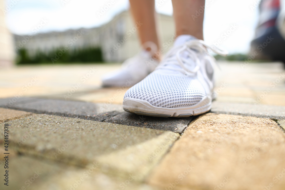 Close-up of person wearing shiny white sneakers Close-up of person wearing shiny white sneakers