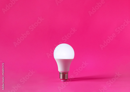 Glowing light bulb on magenta background. Discovery, invention, new idea concept.