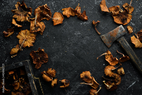 Dried wild mushrooms on a black stone background. Autumn food. Top view. Free space for text.