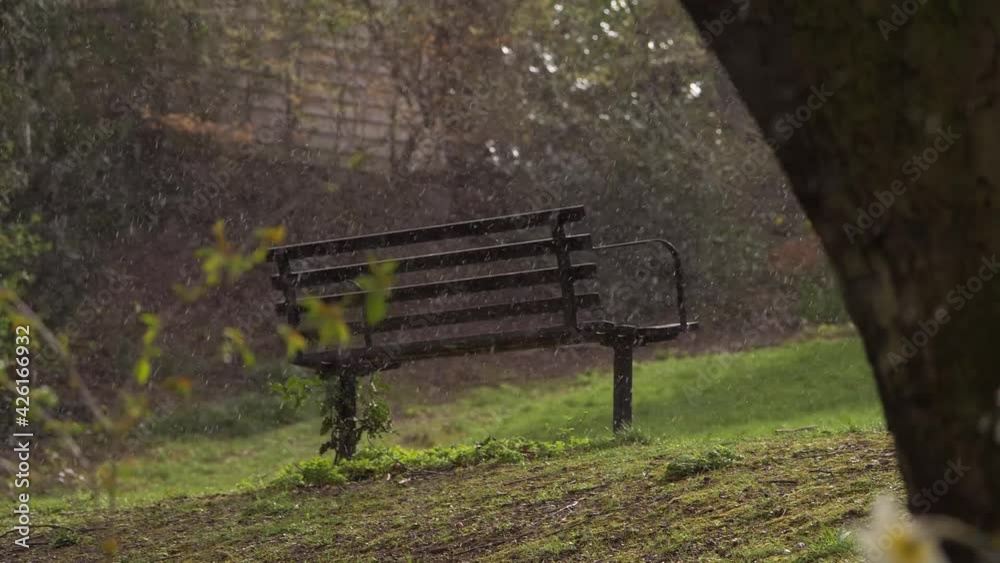 Hail and sleet storm in park with bench Hail and sleet storm in park with bench