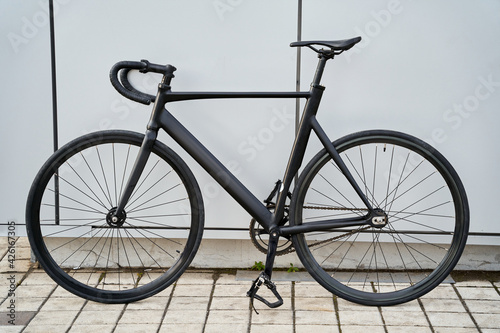 Black city bicycle against grey wall in the city © Friends Stock