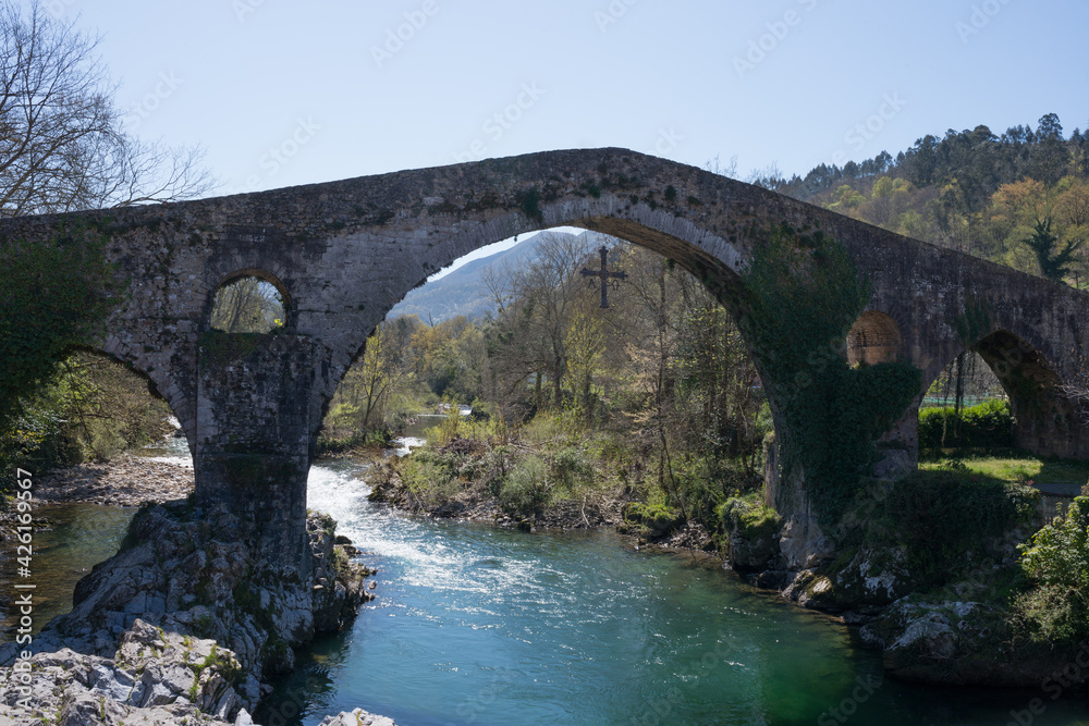 Roman bridge of Cangas de Onis, Asturias, over the Sella river, with no people. Victory cross hanging from the bridge..