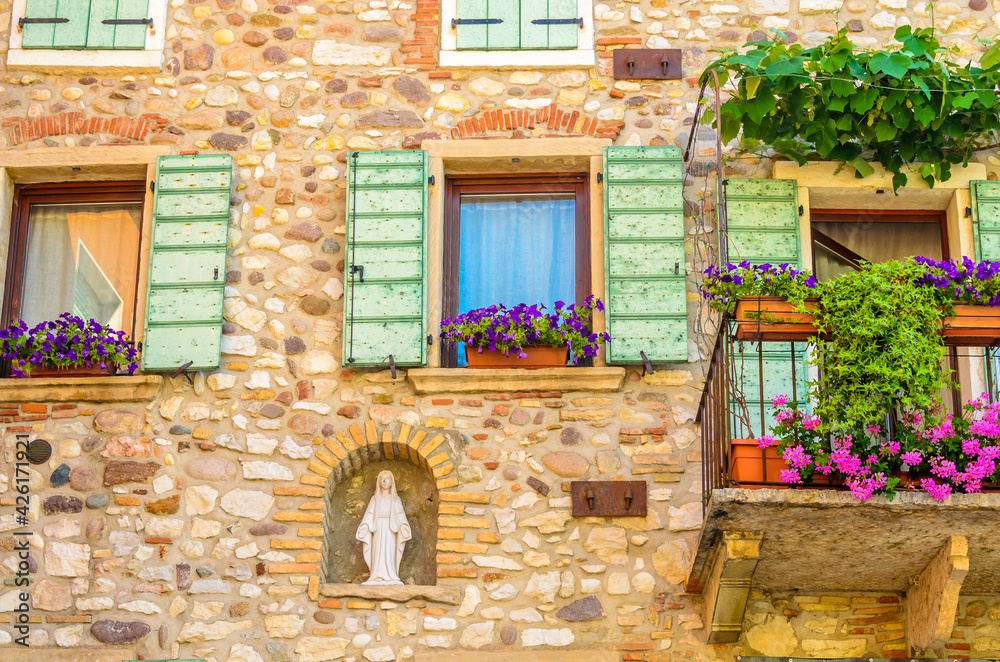 Fototapeta premium Beautiful window decorated with flowers in Italy.