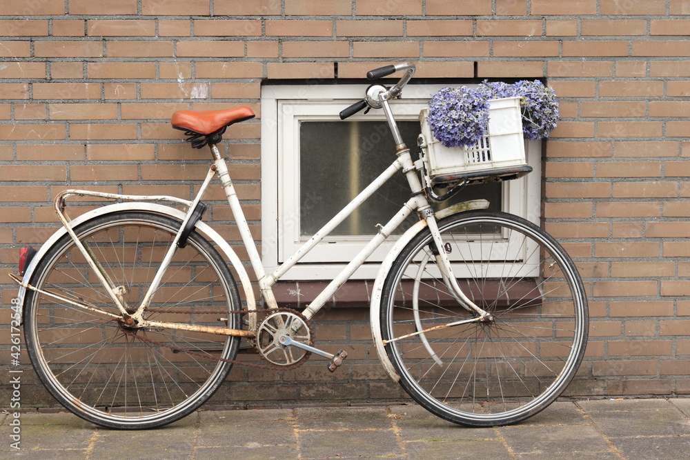 White Vintage Bicycle with Fake Purple Flowers in a Basket in Amsterdam, Holland