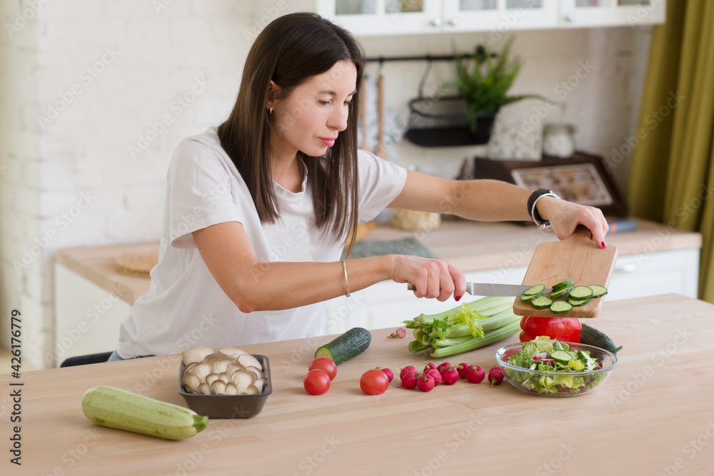 woman prepares salad in the kitchen at home. healthy eating. woman prepares salad in the kitchen at home. healthy eating.