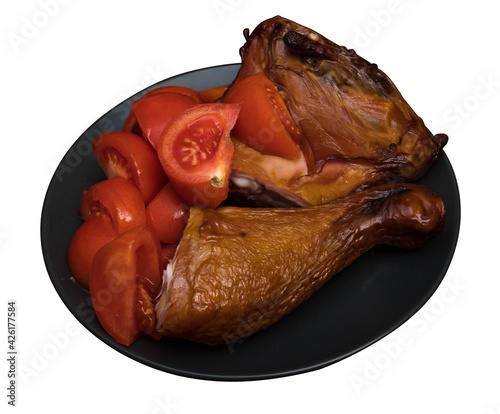 Chicken meat and tomatoes on a black plate, on a white background in isolation