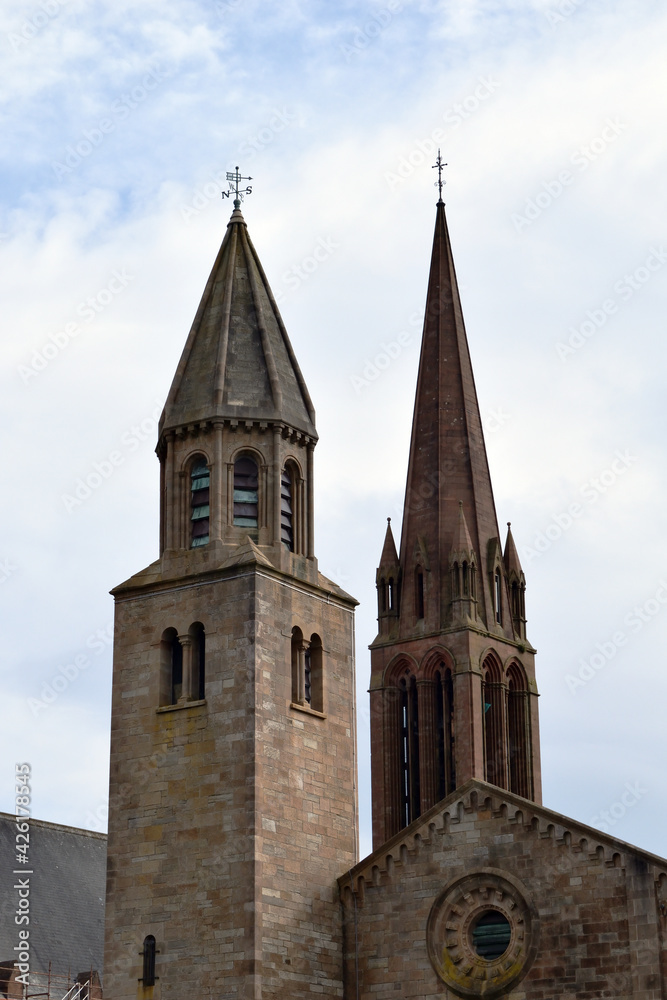 Twin Stone Tower & Spire of Church seen against Cloudy Sky 