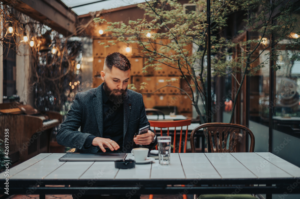 Businessman using a smartphone while working in a cafe