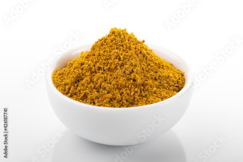 Fototapeta Naklejka Na Ścianę i Meble -  Ras el hanout moroccan spice powder. Ras el hanout in white bowl, on white background. Moroccan spice