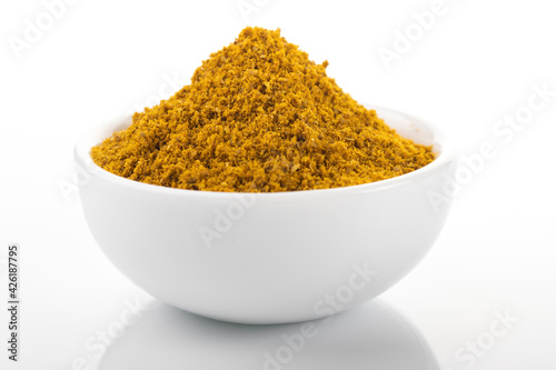 Ras el hanout moroccan spice powder. Ras el hanout in white bowl, on white background. Moroccan spice