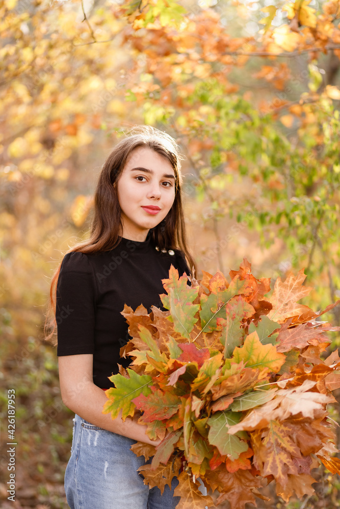 beautiful redhead girl with a bouquet of yellow autumn leaves beautiful redhead girl with a bouquet of yellow autumn leaves