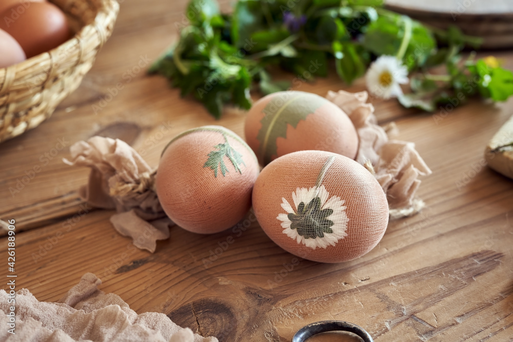 Raw Easter eggs with fresh leaves attached to them, ready to be dyed with onion peels Raw Easter eggs with fresh leaves attached to them, ready to be dyed with onion peels