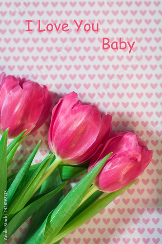 Postcard with the image of beautiful pink tulips on a background with pink hearts, a gift for Valentine's Day. photo