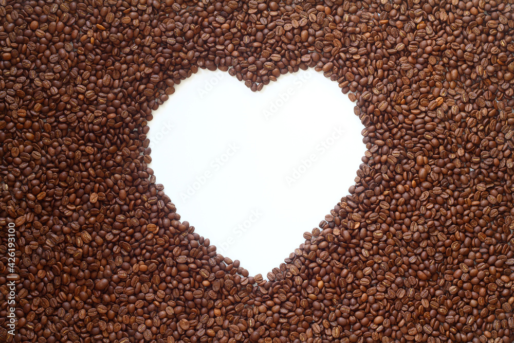 The coffee beans arranged in a heart shape on white background. The coffee beans arranged in a heart shape on white background.