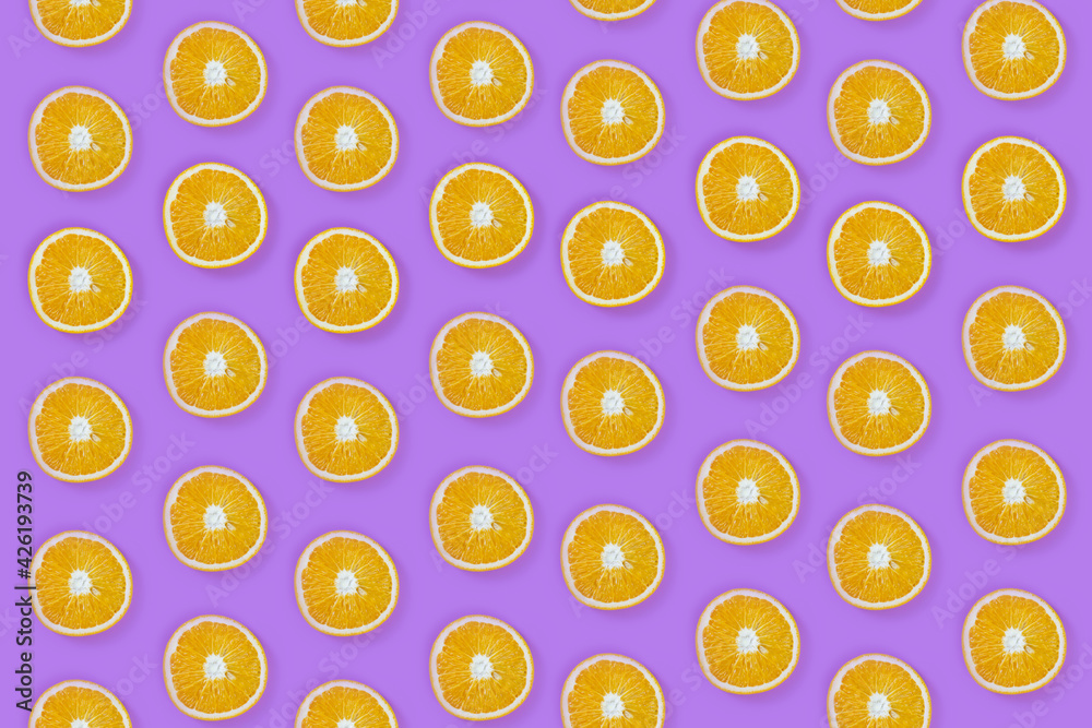 Pattern of fresh slice oranges on purple background
