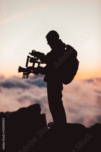 Fotografia Videographer man shooting footage using dlsr camera mounted on gimbal stabilizer equipment