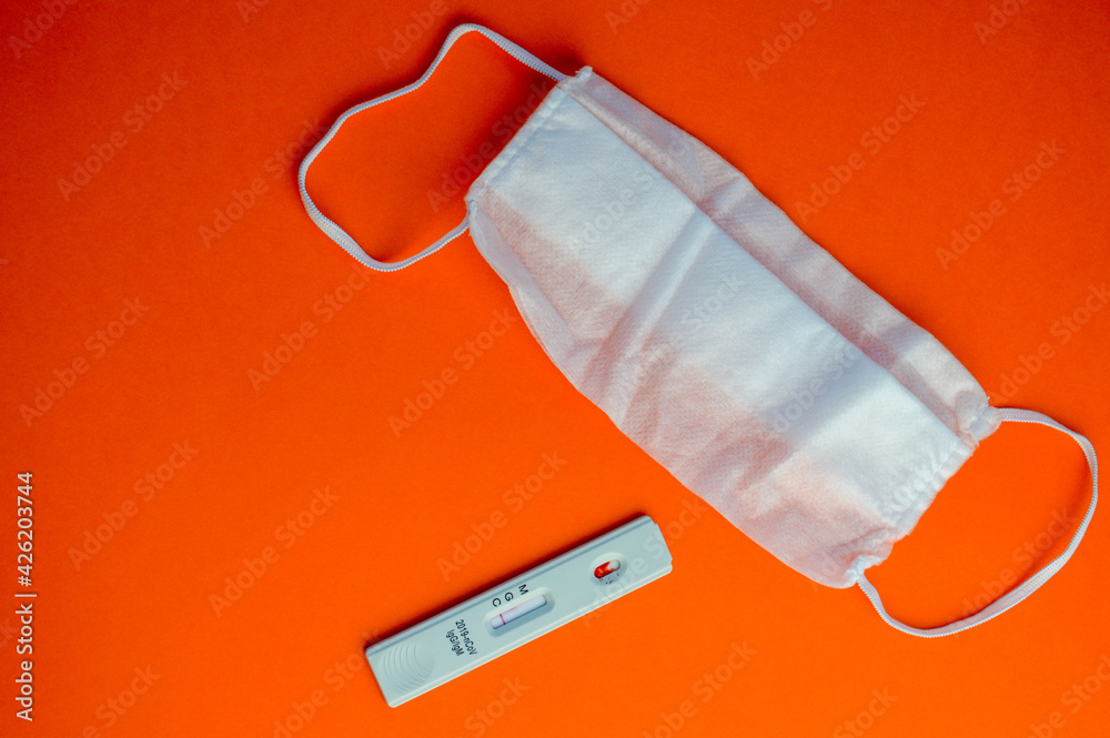 test for coronavirus on an orange background. on a matte background a sensitive strip for coronavirus, a mask. taking care of your health test for coronavirus on an orange background. on a matte background a sensitive strip for coronavirus, a mask. taking care of your health
