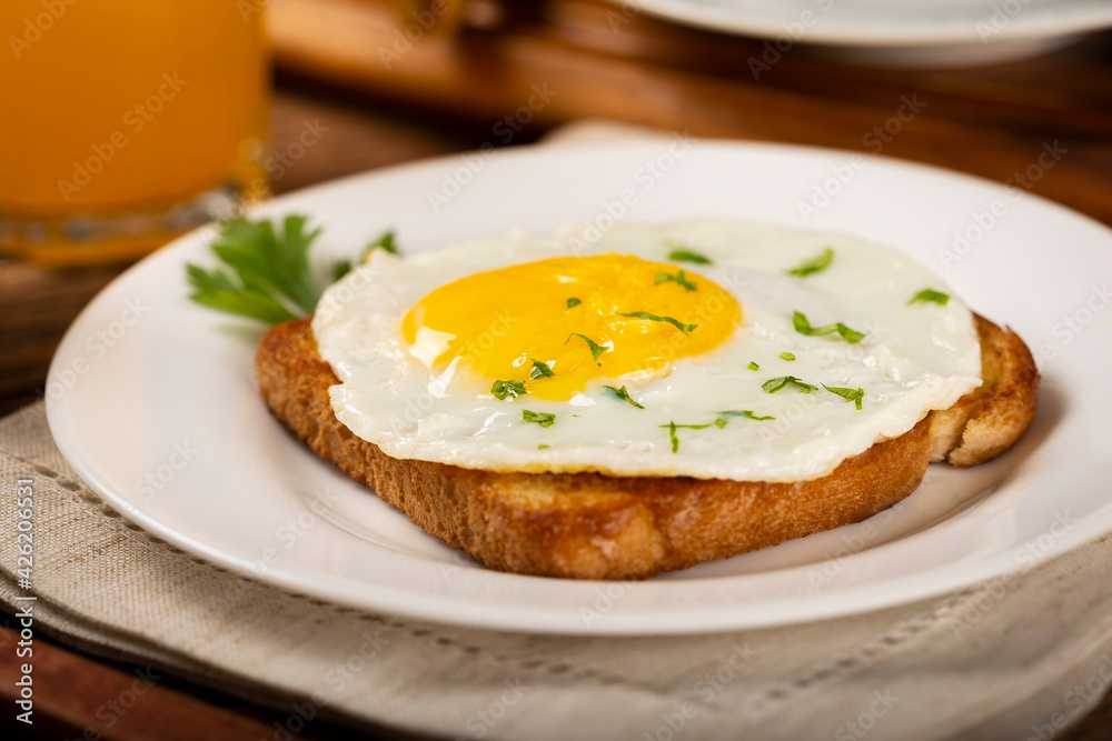 Breakfast with juice, coffee and toast with fried egg.