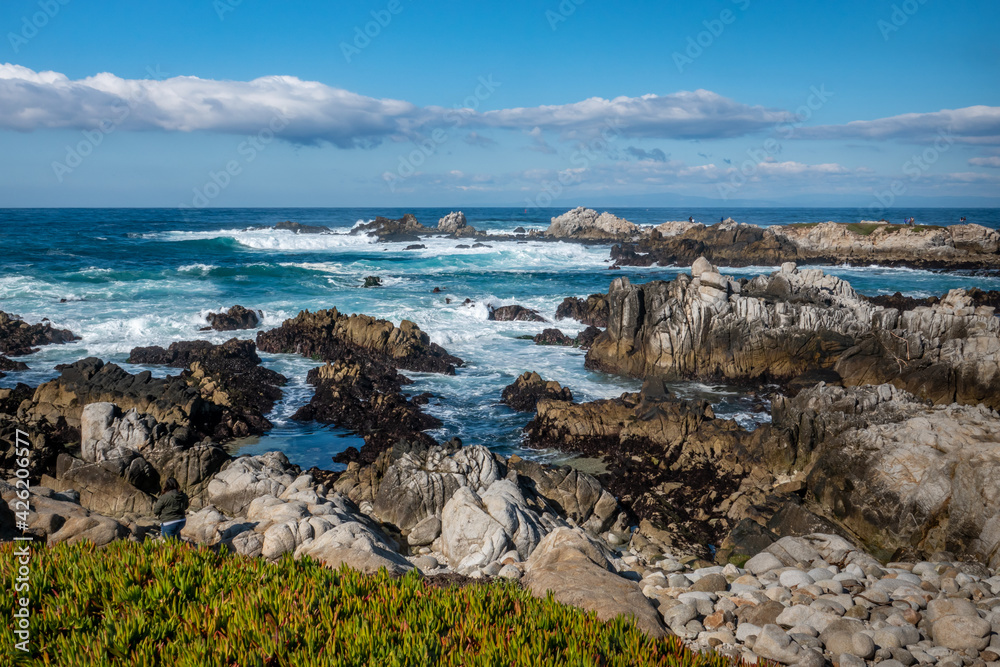 Waves break along the rocky coastal shores of the Monterey Bay at Asilomar Beach, in Pacific Grove, along the central coast of California.