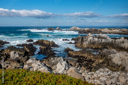 Waves break along the rocky coastal shores of the Monterey Bay at Asilomar Beach, in Pacific Grove, along the central coast of California. photo