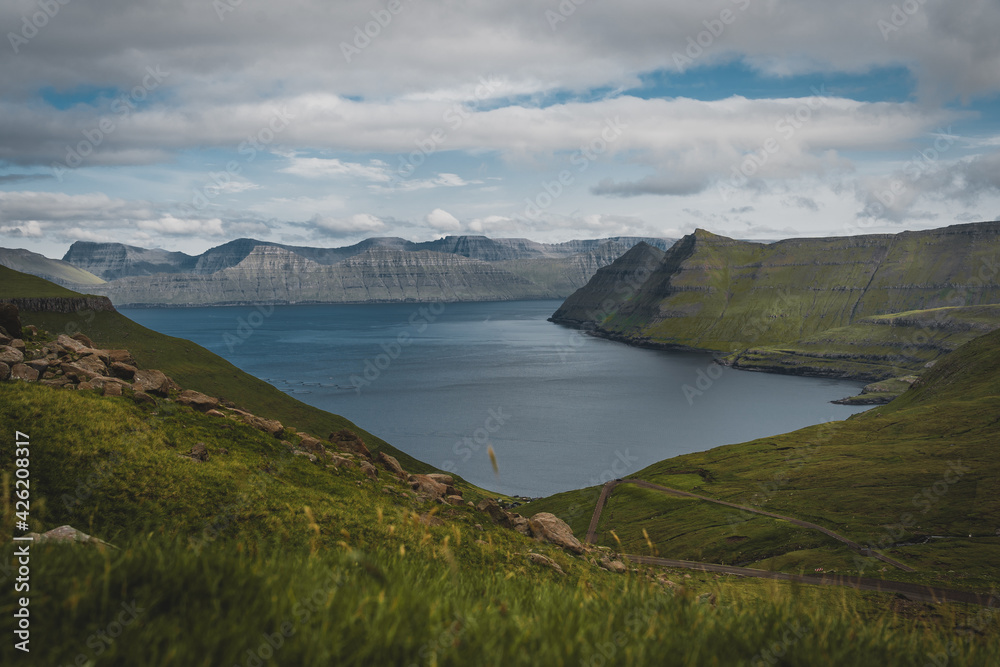 Spectacular views of the scenic fjords on the Faroe Islands near the village Funningur with mountains during a sunny spring day.