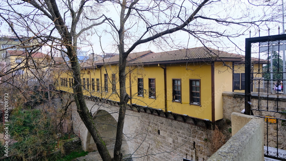 29.03.2021. Bursa Turkey. Old and ancient irgandi bridge during rainy and overcast day behind the dried and withered branches.