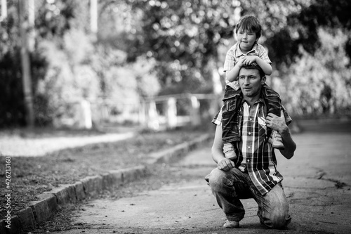 Portrait of daddy and his little son in the park. Black and white photo.