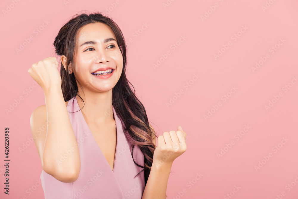 Happy Asian portrait beautiful cute young woman standing winning and surprised excited screaming open mouth raise hands, studio shot isolated pink background, Thai female wow with copy space Happy Asian portrait beautiful cute young woman standing winning and surprised excited screaming open mouth raise hands, studio shot isolated pink background, Thai female wow with copy space