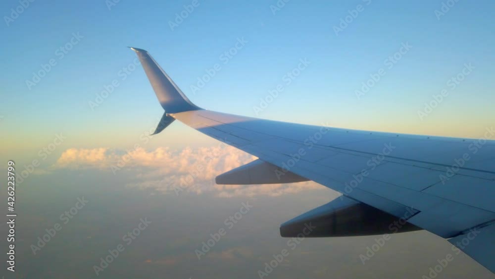 Airplane flying above clouds in clear sky. Passenger point of view Airplane flying above clouds in clear sky. Passenger point of view
