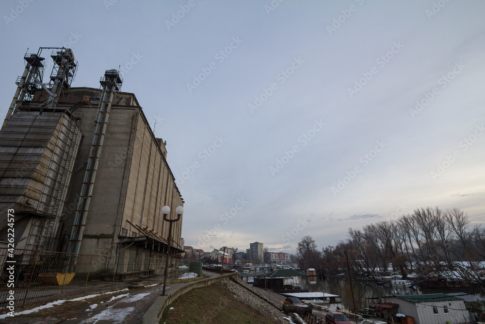 Panorama of the Tamis river, on Pancevo Waterfront in the center of the city, during a cold winter snow sunset. Iconic silos are visible in background. Panorama of the Tamis river, on Pancevo Waterfront in the center of the city, during a cold winter snow sunset. Iconic silos are visible in background.