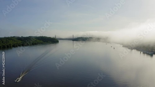 BINACIONAL DRONE AMAPA AMAZONIA DAWN WITH MIST BOAT ON THE OIAPOQUE RIVER DIVISES WITH FRENCH GUIANA