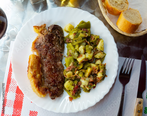 Spicy roasted veal entrecote with dish of baked vegetables