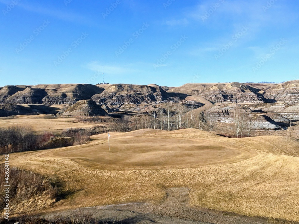 Beautiful vistas of a golf course in the badlands surrounded by canyons, hoodoos, coulees and mountains outside of Drumheller, Alberta, Canada