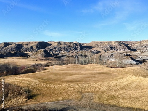 Beautiful vistas of a golf course in the badlands surrounded by canyons, hoodoos, coulees and mountains outside of Drumheller, Alberta, Canada