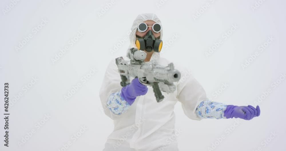 Man in white chemical protection suite aims with fake assault rifle, slow motion Man in white chemical protection suite aims with fake assault rifle, slow motion